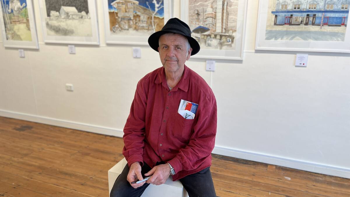 Artist Andy Doyle sits on a plinth inside Spiral Gallery, Bega, during his exhibition. Picture by James Parker