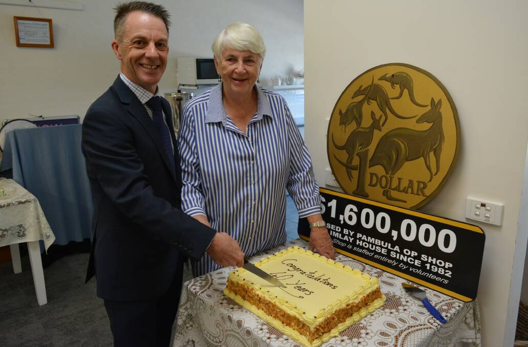 Sapphire Coast Community Aged Care CEO Matt Sierp and Pambula op shop volunteer Alison Jenkins cut the store's 40th birthday cake on Saturday. Pictures by Ben Smyth