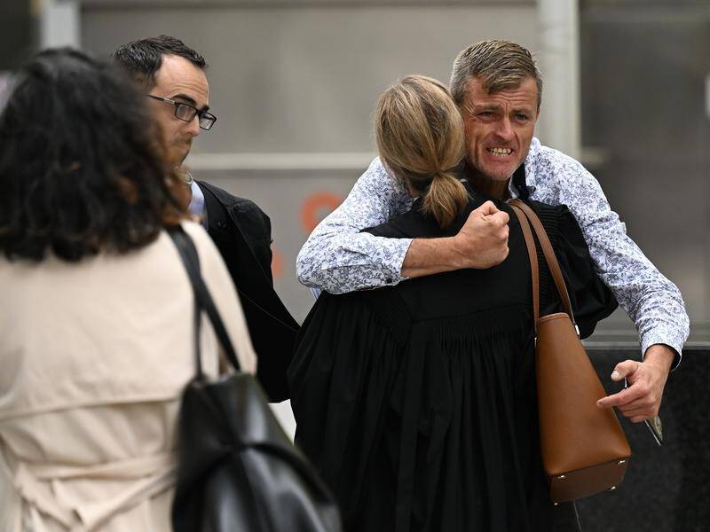 Bryan Beattie (far right) hugged the prosecutor after he heard his son's killers had been convicted. (James Ross/AAP PHOTOS)